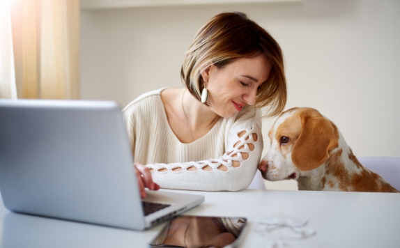 woman and dog sitting at computer