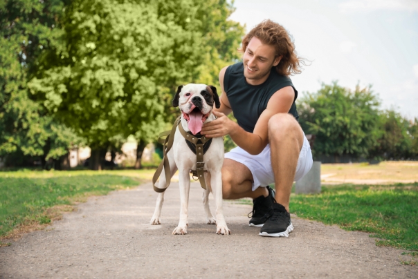 man kneeling and petting dog